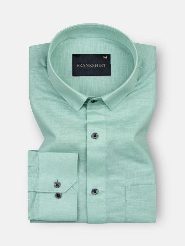 A green, long-sleeved, button-down linen shirt with a chest pocket on the left side.
