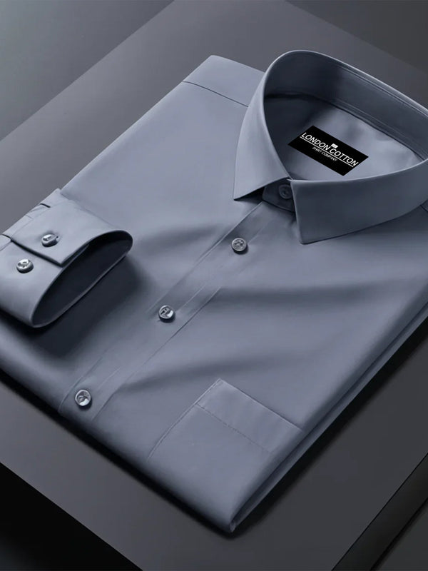 Folded gray dress shirt with a brand label on a dark surface