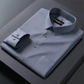 Folded gray dress shirt with a brand label on a dark surface