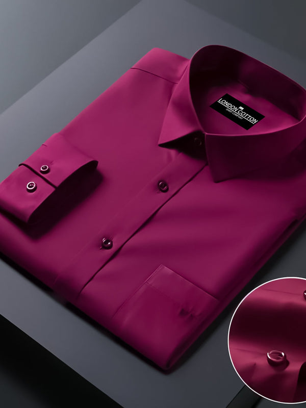 Folded magenta shirt with brand label on a dark surface