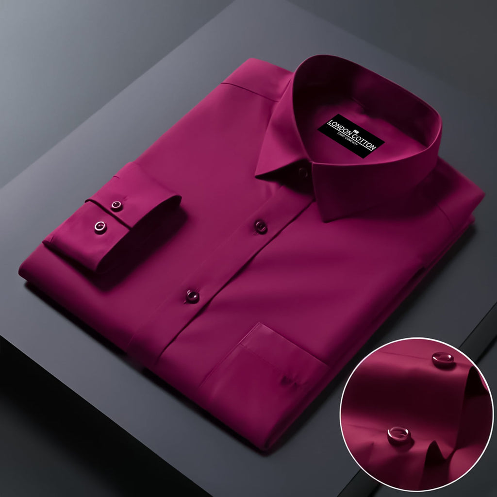 Folded magenta shirt with brand label on a dark surface