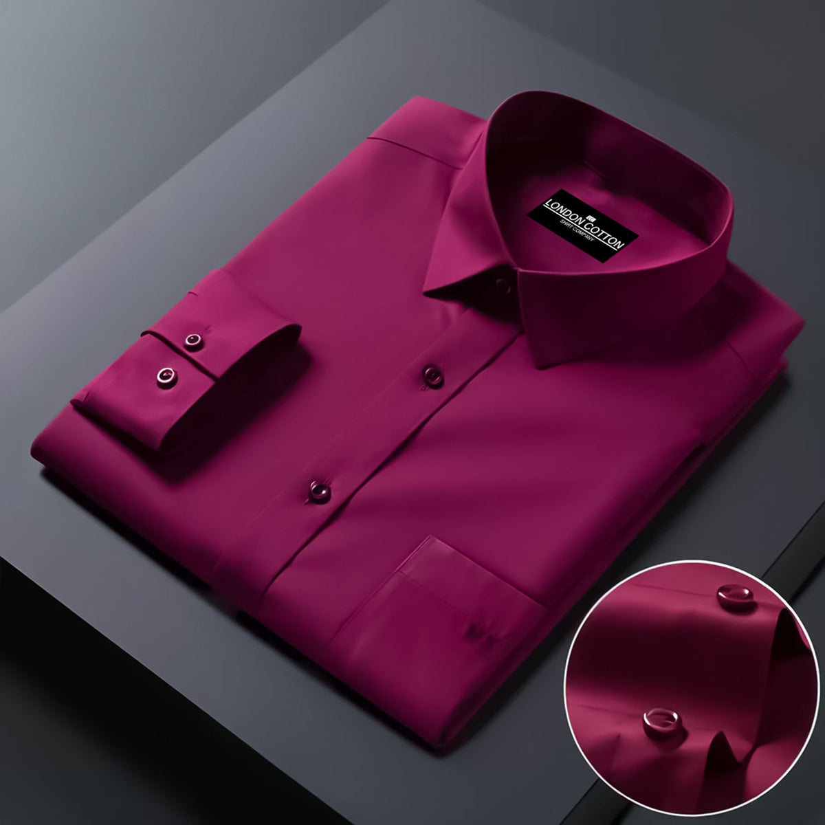 Folded magenta shirt with brand label on a dark surface